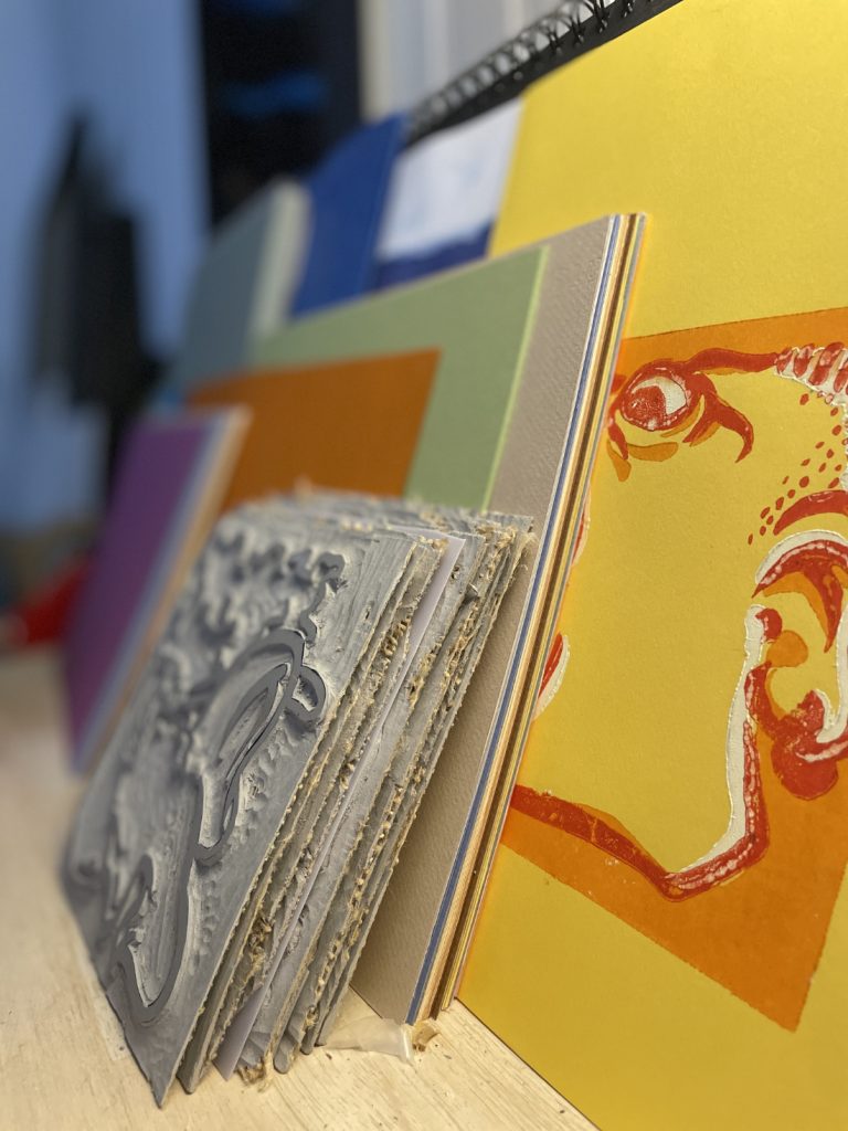 quelques plaques de linoléum et des feuilles de papiers de couleur prêts pour l'impression
